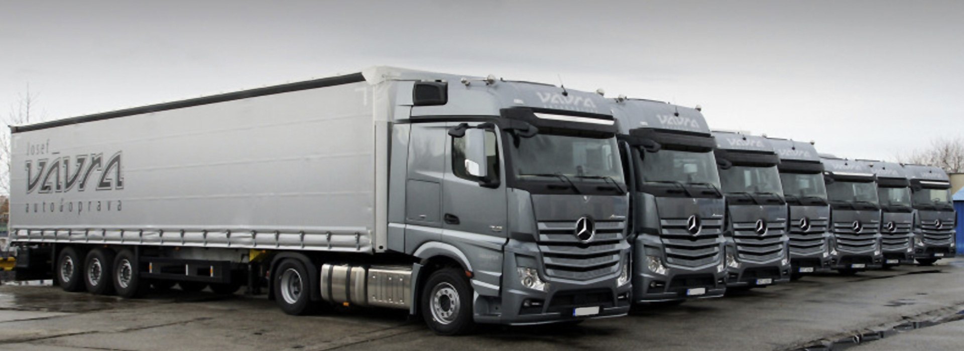 Řada kamionů Mercedes-Benz s návěsy Josef Vávra na firemním překladišti